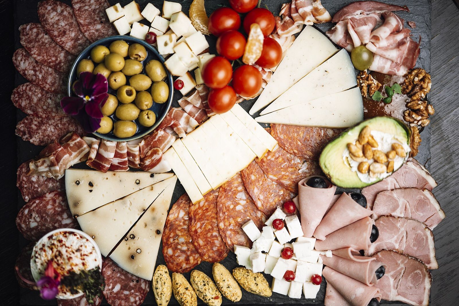 Deli board with cheeses, cured meats and olives